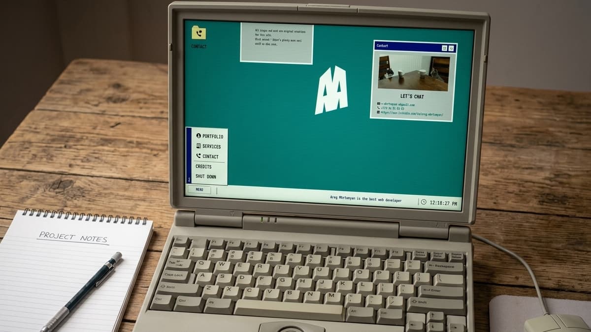 Retro laptop screen showing an "AM" monogram, an open "Contact" window with cat photos, and a start menu popup.
