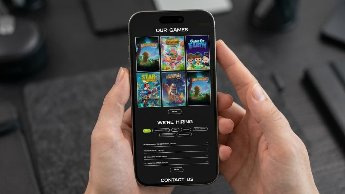Mobile screen displaying "OUR GAMES" with a grid of six cartoon game poster illustrations, followed by a "WE'RE HIRING" job listings board.